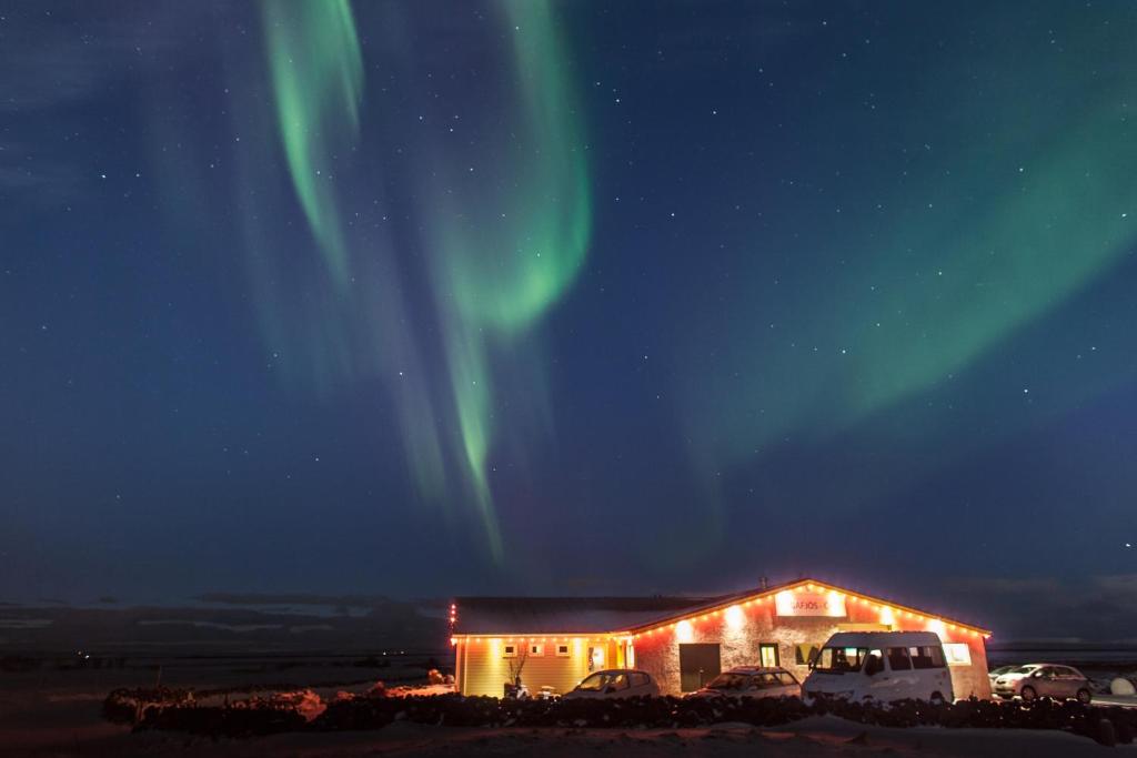 um edifício com a aurora no céu em Vogafjós Farm Resort em Myvatn