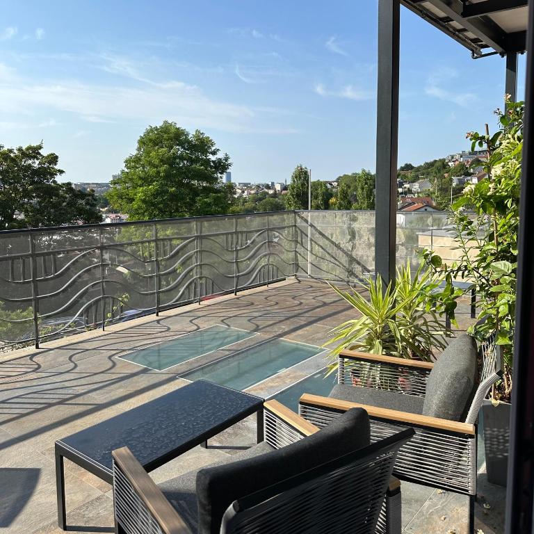 un patio avec une table et des chaises sur un balcon dans l'établissement La Maison Du Coteau, à Cachan