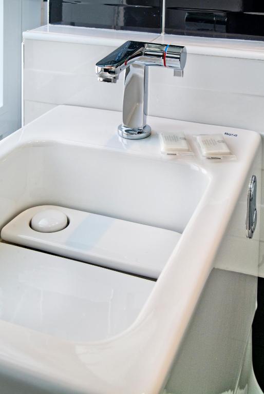a white bathroom sink with a faucet at JC Rooms Santo Domingo in Madrid