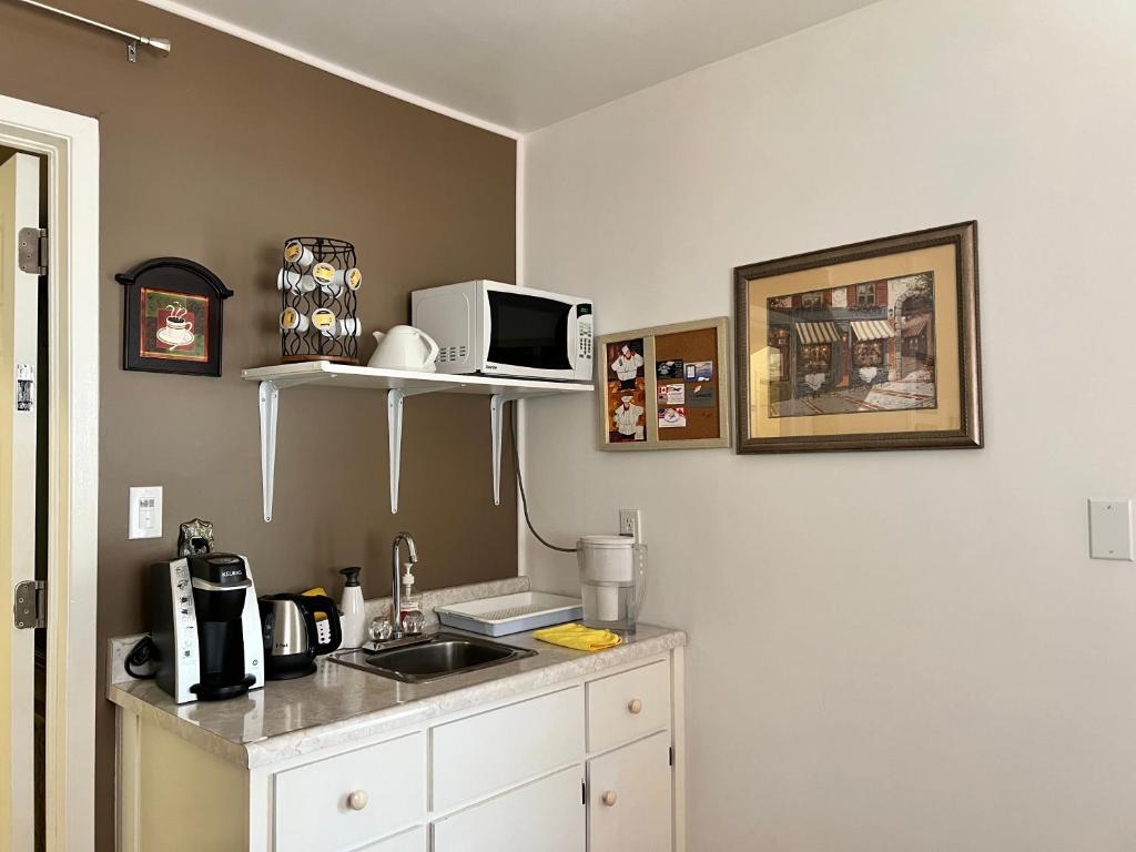 a kitchen with a sink and a microwave on a wall at Cozy House B&B in Niagara Falls