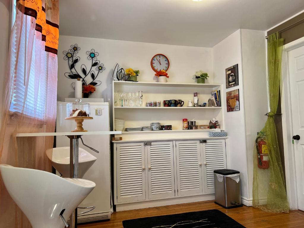 a room with white shelves and a table and a chair at Cozy House B&B in Niagara Falls