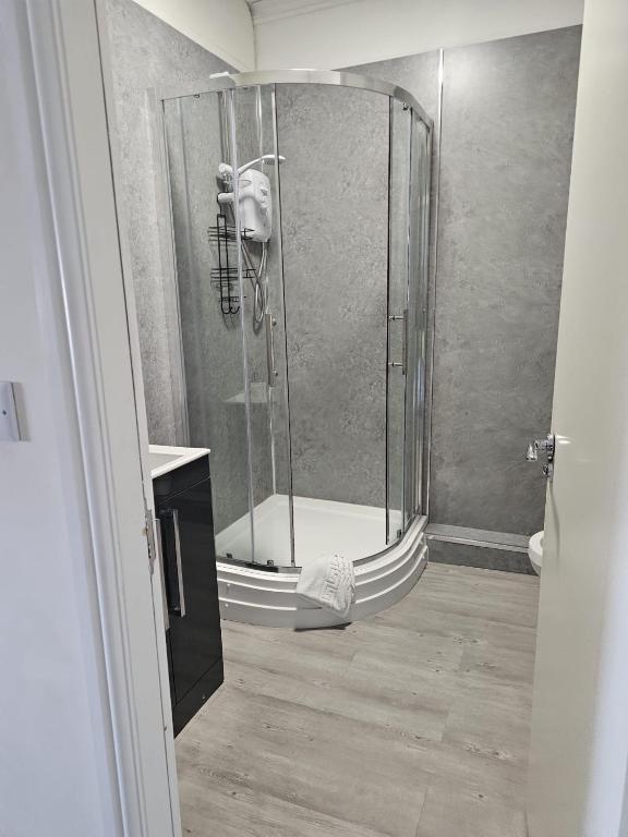 a shower with a glass door in a bathroom at The New Brighton Hotel in New Brighton