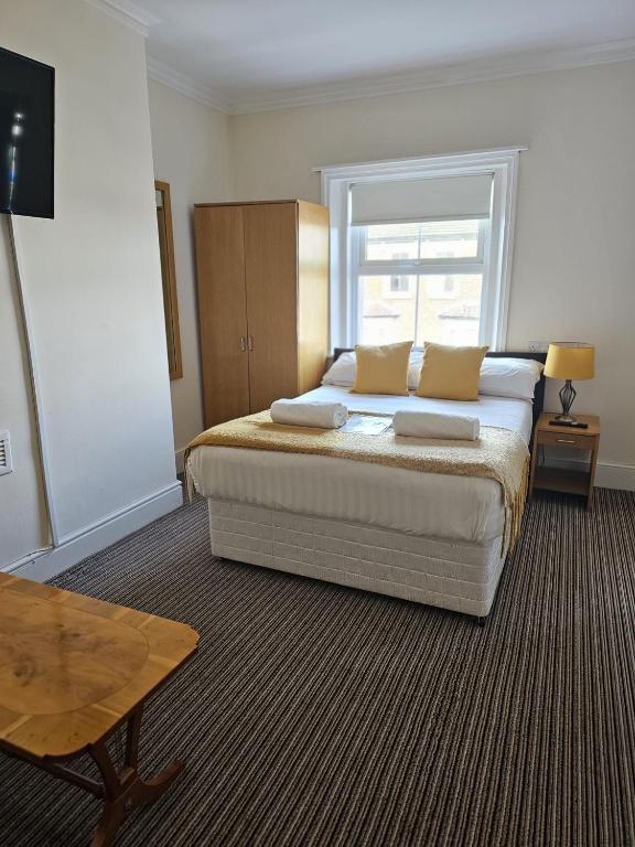 a bedroom with a bed with pillows and a window at The New Brighton Hotel in New Brighton