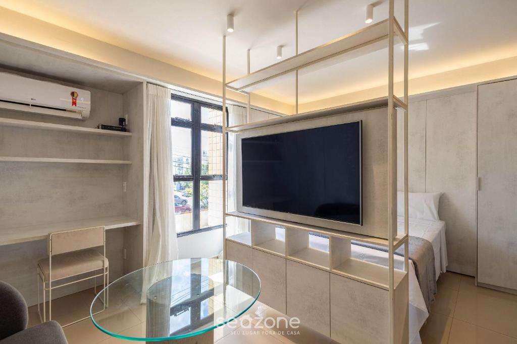 a living room with a tv and a glass table at Studio Moderno em Lago Norte SHL0105 in Brasilia