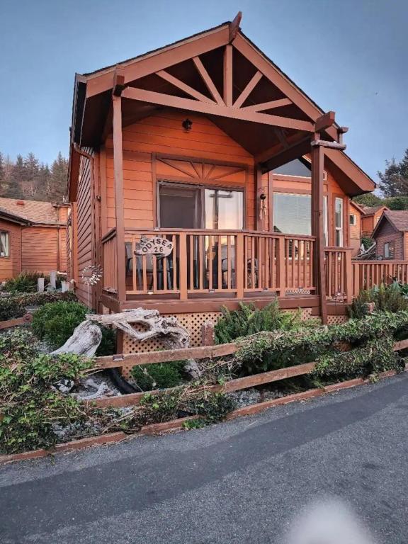 a log cabin with a porch and a deck at Odysea Ocean Cabin 26 w Jacuzzi & Modern Decor in Smith River