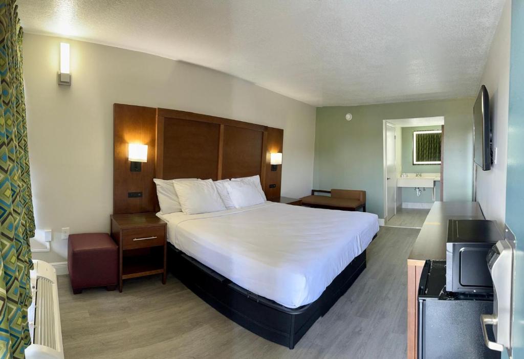 Una habitación de hotel con una cama grande y un televisor. en Rodeway Inn Davenport-Champions Gate, en Davenport