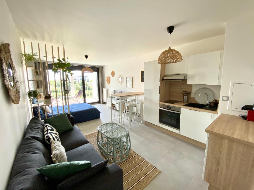 un salon avec un canapé et une cuisine dans l'établissement Studio Hakuna Matata Disney 5 min Parking, à Montévrain