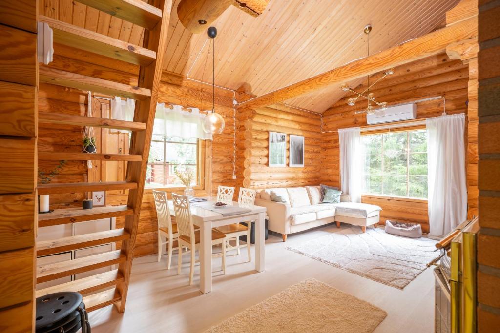 ein Wohnzimmer mit Tisch und Couch in der Unterkunft Lapin Villa Hiisi joen rannalla in Ranua