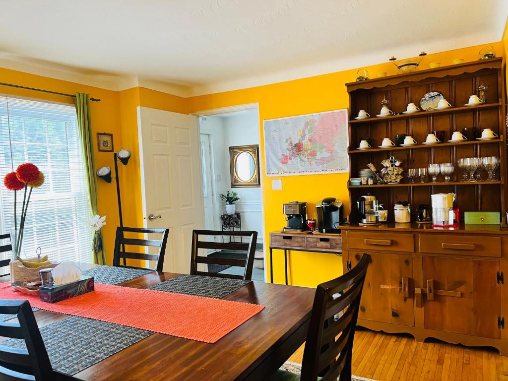 a dining room with a table and a kitchen at Cozy House B&B in Niagara Falls