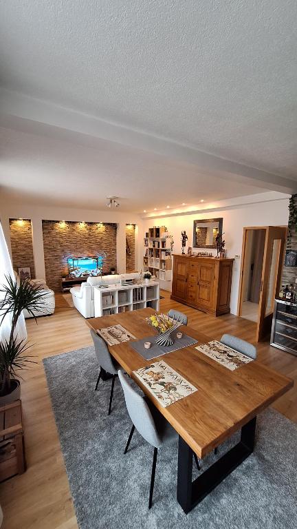 Il comprend un salon avec une table en bois et une cuisine. dans l'établissement appartement design et loisirs proche Saverne, à Dettwiller