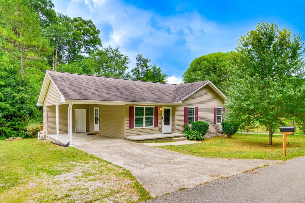 a small yellow house with a driveway at Campton Cottage with Hot Tub, Near Hiking and Climbing in Rogers