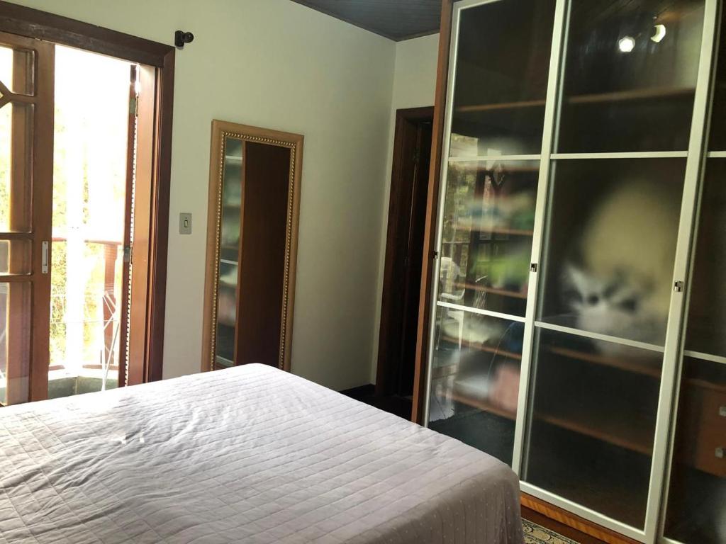a bedroom with a cat sitting in a glass cabinet at Aconchegante Apartamento in Campos do Jordão