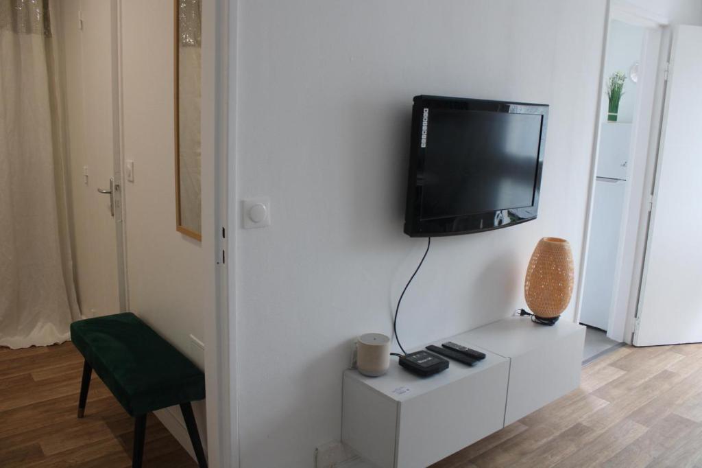 un salon avec une télévision sur un mur blanc dans l'établissement Studio, à Livry-Gargan