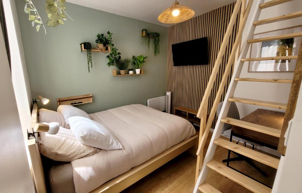 Un pequeño dormitorio con una cama y una escalera en le Savannah, en Saint-Omer