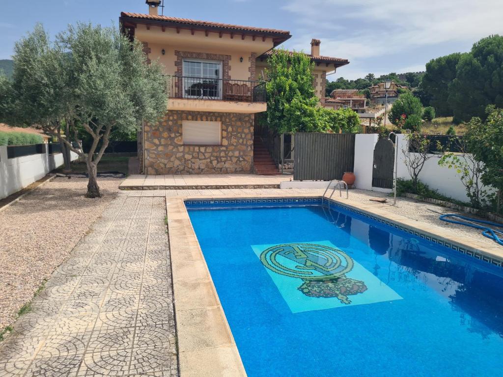 une villa avec piscine devant une maison dans l'établissement Chalet el castillo, à La Adrada