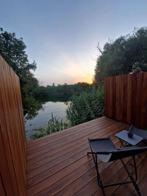 une terrasse en bois avec une table et une chaise. dans l'établissement Suite avec jacuzzi & terrasse vue sur l'Orb, à Béziers