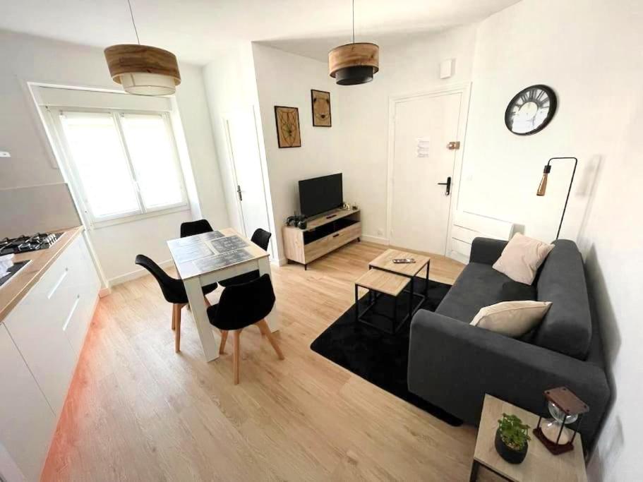 a living room with a couch and a table at La Reconquête des remparts in Hennebont