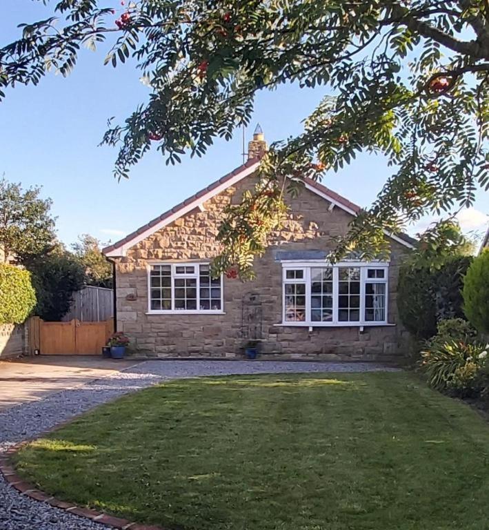 a brick house with a yard in front of it at Willow Cottage 3 bed, cosy stopover, dogs welcome in Thornton-le-Beans