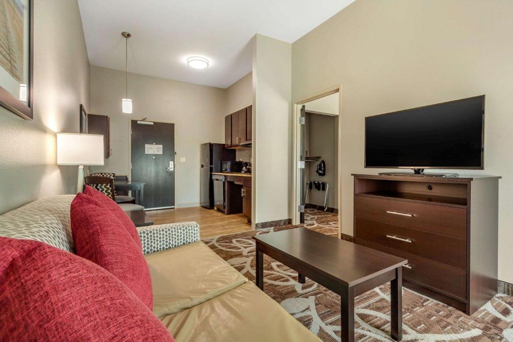 a living room with a couch and a flat screen tv at MainStay Suites Lincoln University Area in Lincoln