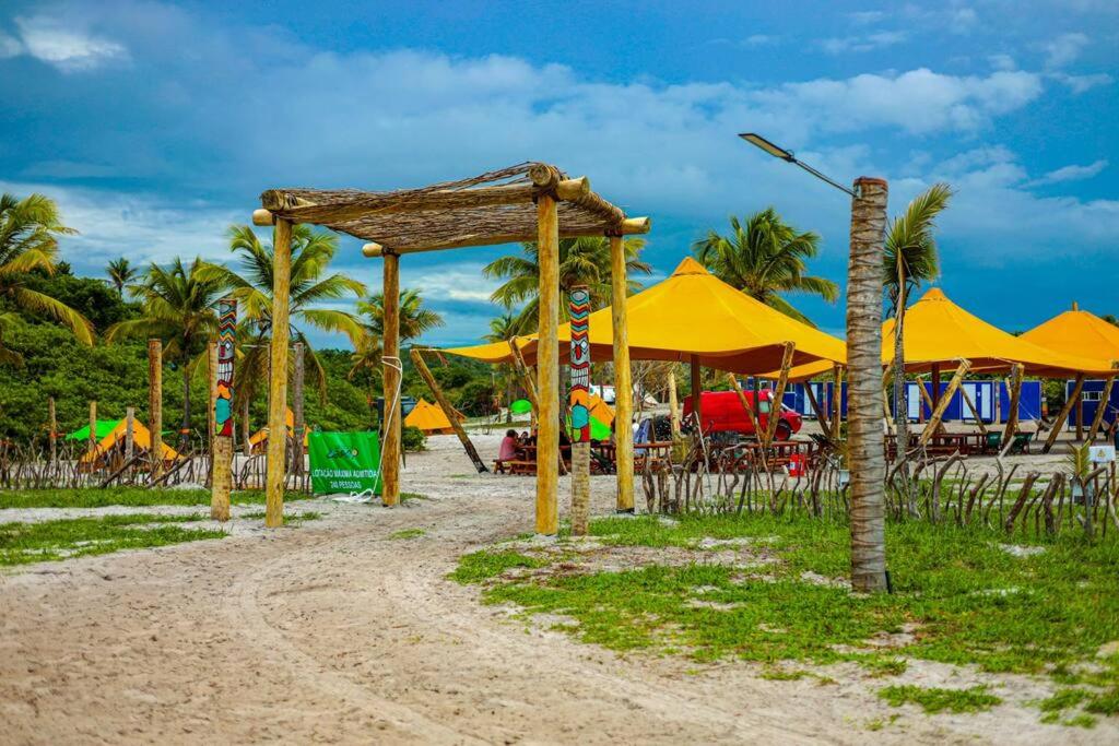 un parco giochi con ombrelloni gialli su una spiaggia di Arteco Camp a Baía Formosa