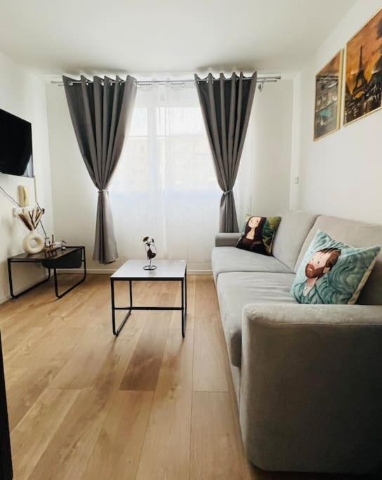 un salon avec un canapé et une table dans l'établissement Studio cozy - Paris La Défense Arena - Courbevoie, à Courbevoie