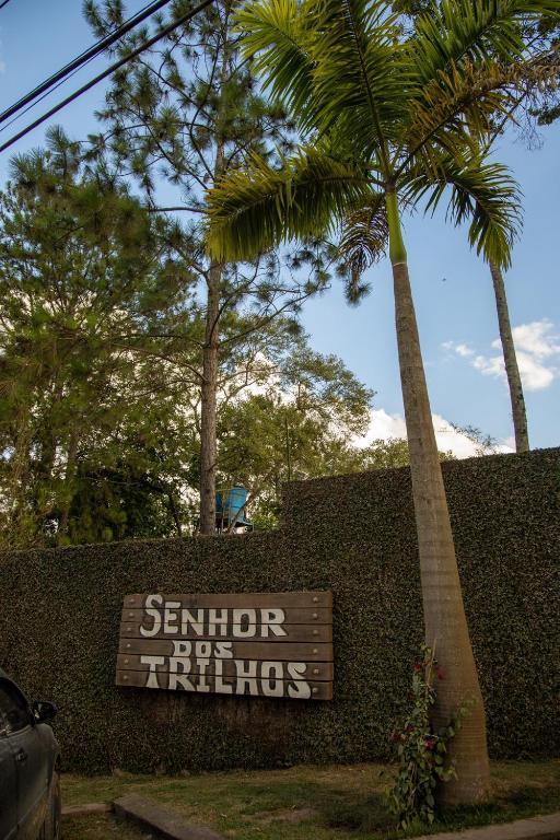 a sign for a school for things with a palm tree at Chalés Senhor Dos Trilhos in Mairiporã