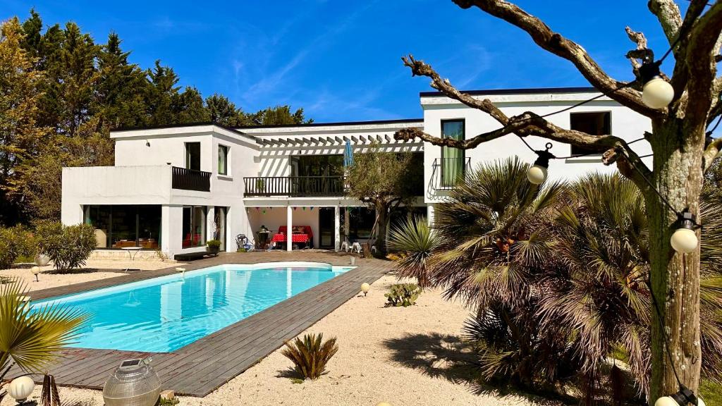 une maison avec une piscine devant dans l'établissement Villa Californienne du soleil, à La Rochelle