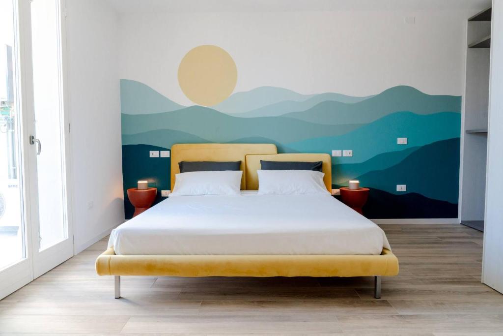 a bedroom with a bed with a mountain mural on the wall at InLoco - Natural Experience in Acqualagna