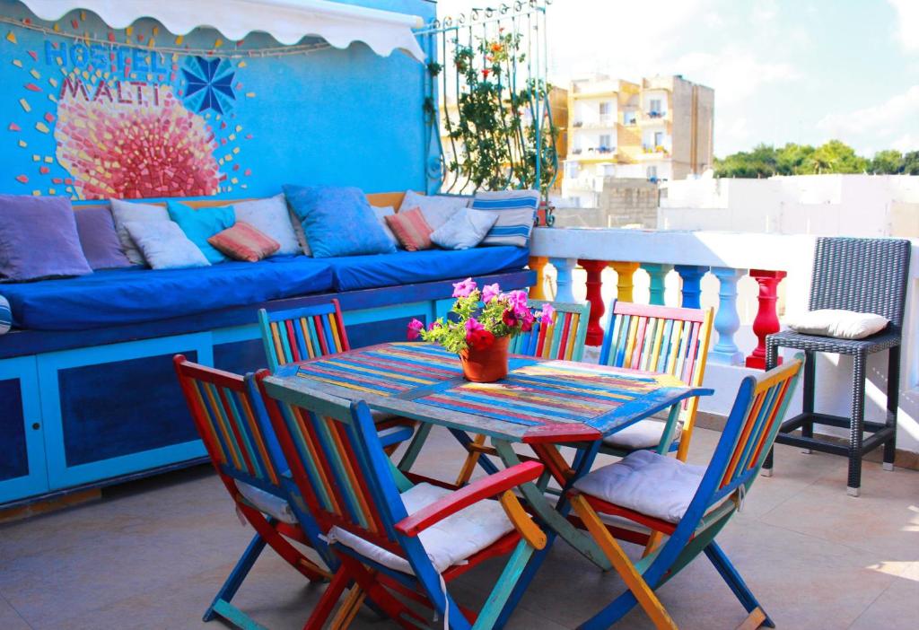 d'un balcon avec une table et des chaises et un canapé. dans l'établissement Hostel Malti Budget, à San Ġiljan