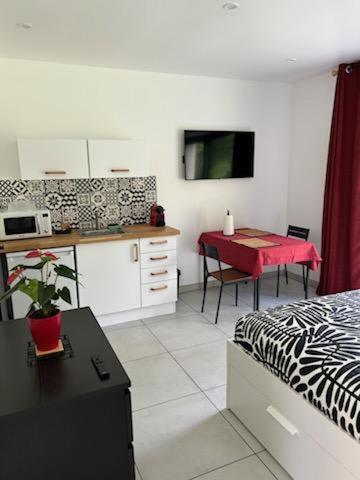 une chambre avec un lit et une cuisine avec une table dans l'établissement Un Coin Paisible, à Lantheuil