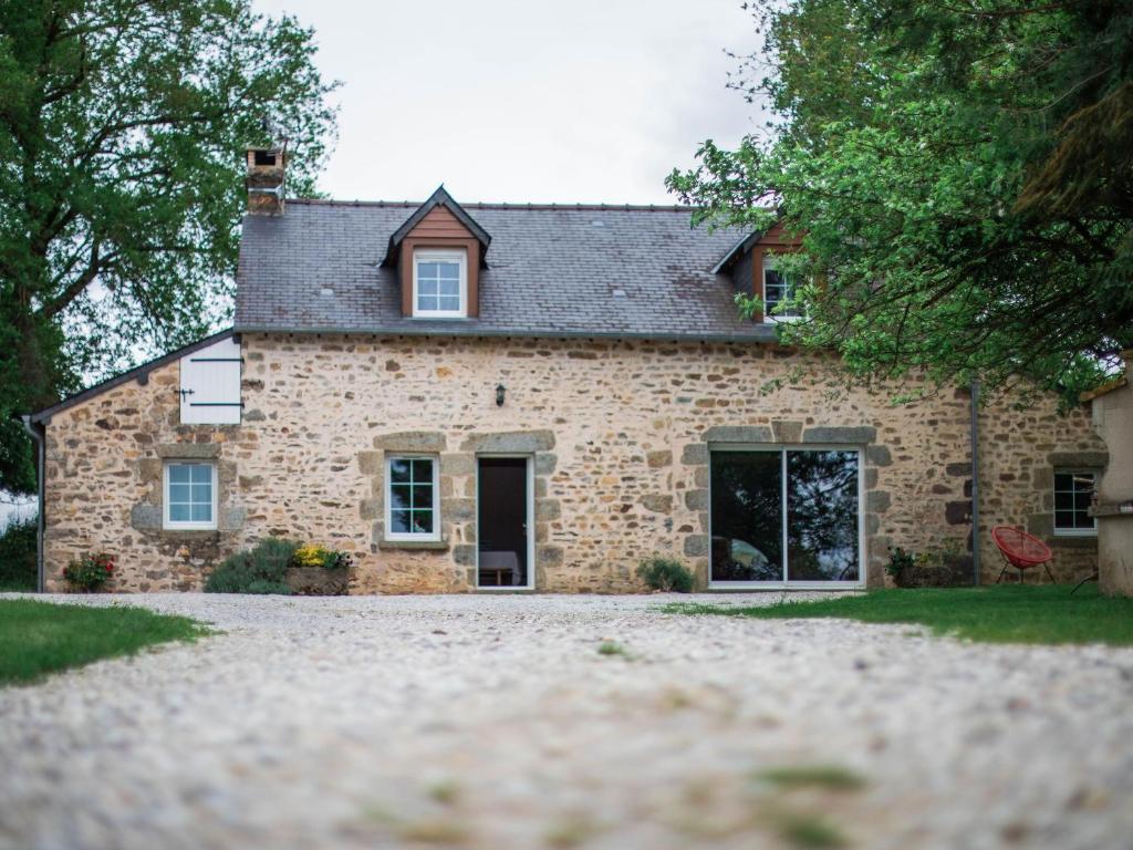 une maison en pierre avec une allée en face de celle-ci dans l'établissement Gîte de charme rénové avec cheminée, terrasse et proche randonnées - Capacité 13 pers. - FR-1-410-179, à Saint-Léonard-des-Bois