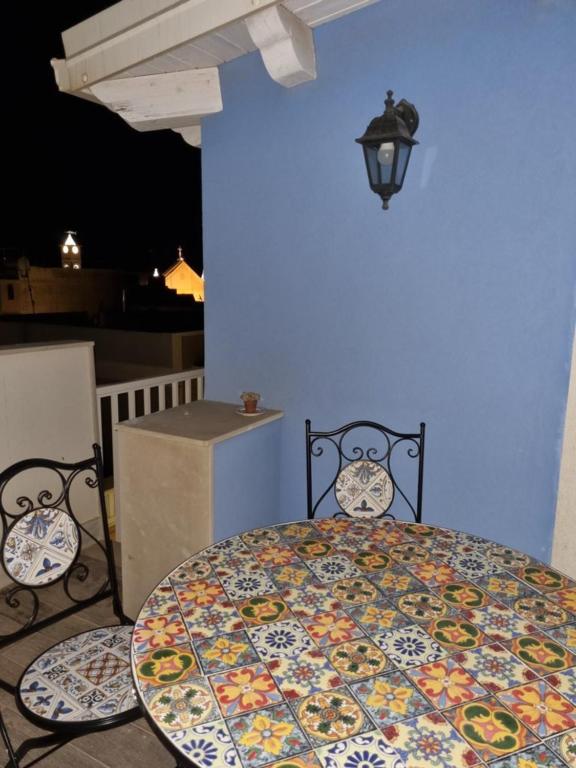 una mesa y sillas en una habitación con una pared azul en Maria Blue House, en Portopalo di Capo Passero