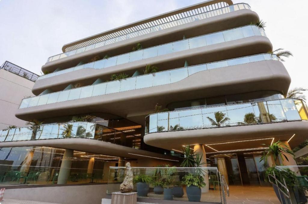 Ein hohes Gebäude mit vielen Pflanzen drauf. in der Unterkunft Setai Yacth, Flat para até 03 pessoas a beira mar do Cabo Branco in João Pessoa