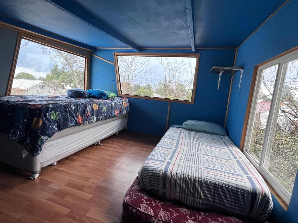 een slaapkamer met een bed en twee ramen bij las cascadas in Puerto Clocker
