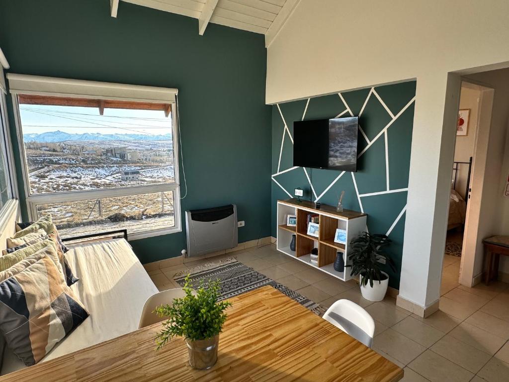 un salon avec une table et une télévision dans l'établissement TAAR AIKE II (Lugar de Hielo), à El Calafate