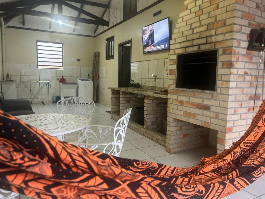 un soggiorno con camino in mattoni e TV di SOBRADO Com 3 QUARTOS NO CORAÇÃO DO COSTA E SILVA a Joinville