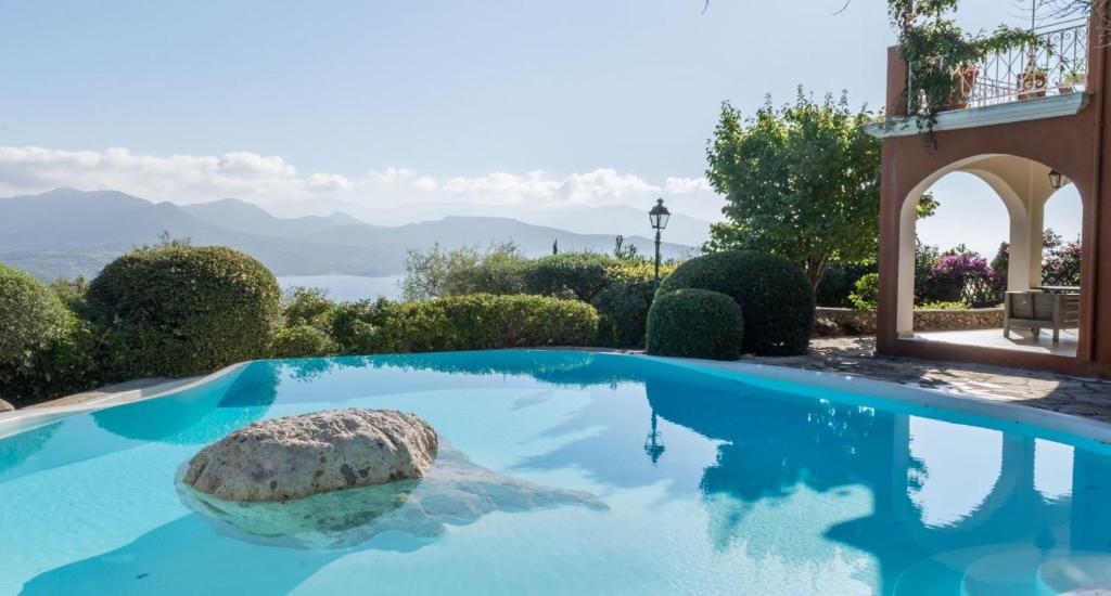 a swimming pool with a rock in the water at Lefkada Collection Villas in Lygia