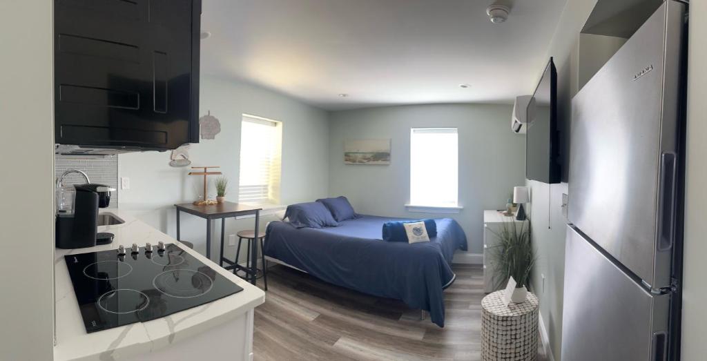 a living room with a blue couch and a kitchen at 318 E Youngs Ave Unit 8 Salty Shore Retreat Idyllic Studio by the Sea in Wildwood
