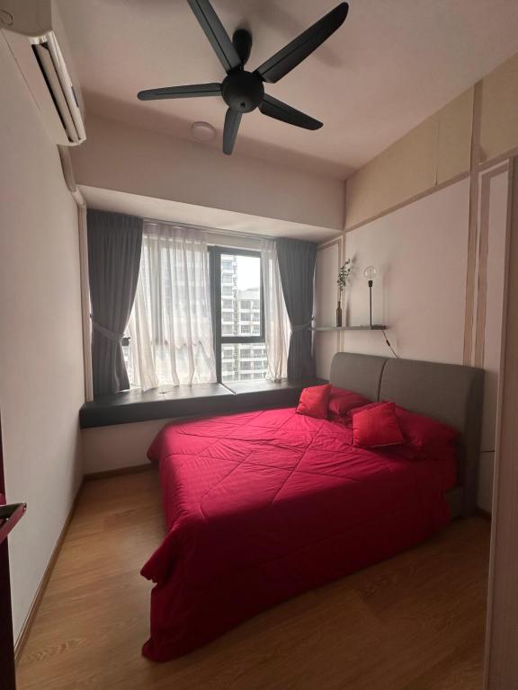 ジョホールバルにあるHomestay Ayuzizan CountryGarden Dangabay JBのベッドルーム1室(赤いベッド1台、天井ファン付)