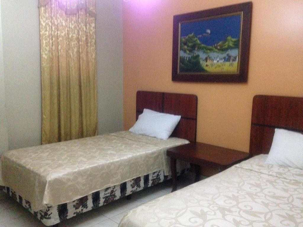 Postel nebo postele na pokoji v ubytování Tropical Inn Hotel