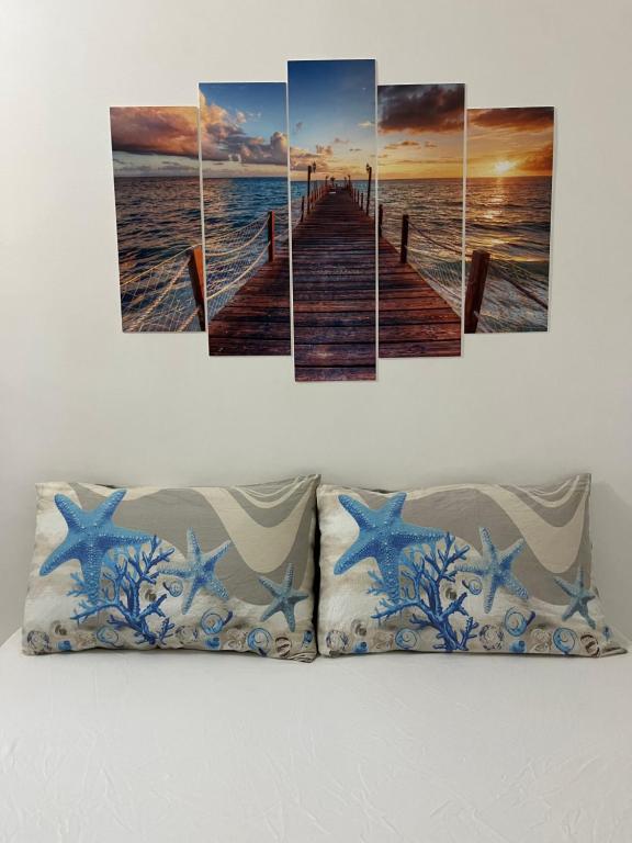 a wooden bridge over the ocean with starfish canvas wall art at Casa Maria Bartolomeo in Marsala