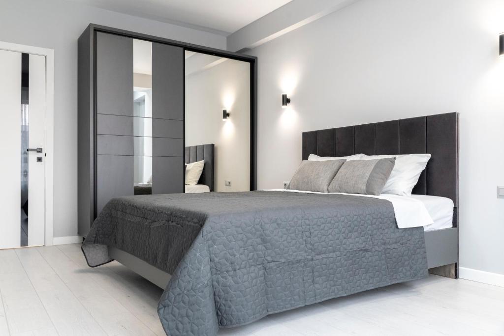 een slaapkamer met een groot bed en een grote spiegel bij RentWill apartments Silver in Chişinău