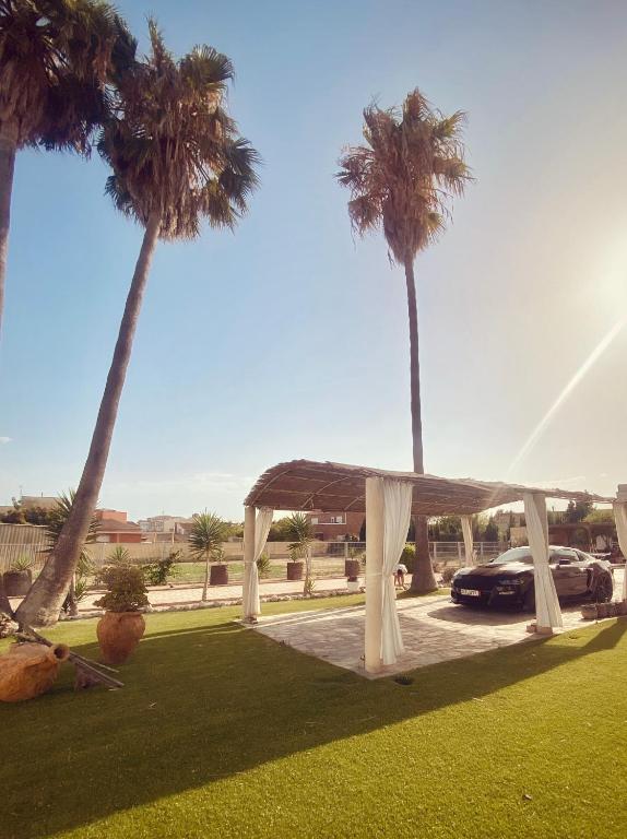 una tenda da matrimonio in un campo con palme di La Villa a Sant Jaume d'Enveja