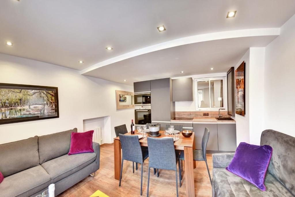 - un salon avec un canapé et une table avec des oreillers violets dans l'établissement Cozy apartment between lake and mountains, à Annecy
