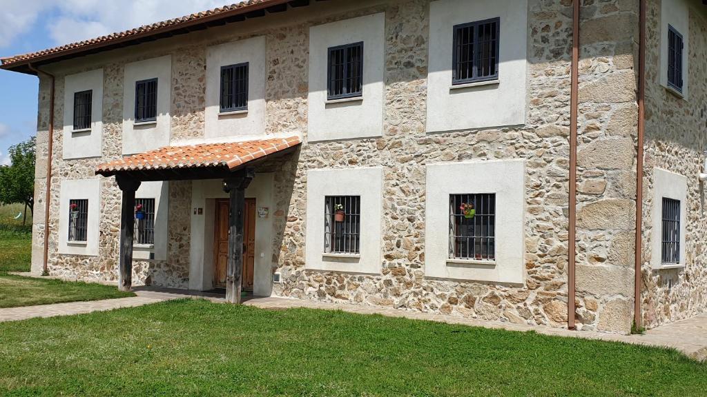 a stone building with a door and windows on it at Finca la Carb0nera in Oliva de Plasencia