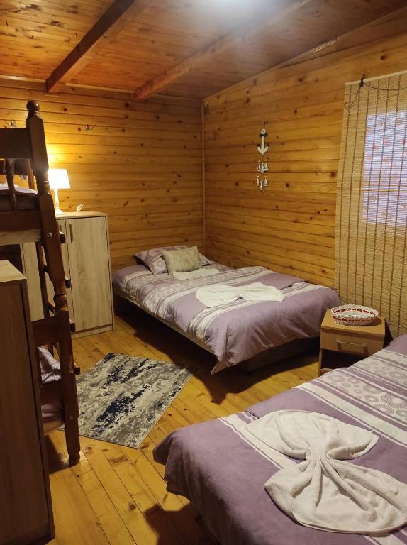 sypialnia z 2 łóżkami w drewnianym domku w obiekcie Vanilla House w Ulcinju