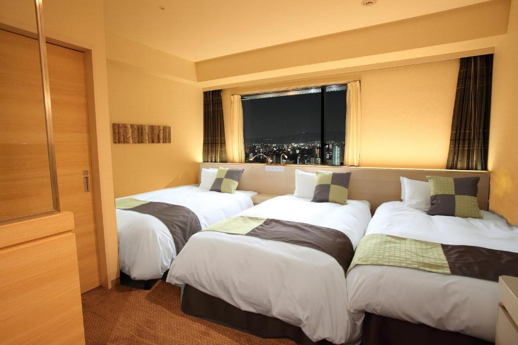Postel nebo postele na pokoji v ubytování Hotel Keihan Kyobashi Grande