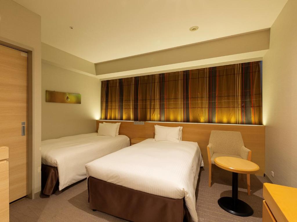 Postel nebo postele na pokoji v ubytování Hotel Keihan Kyobashi Grande