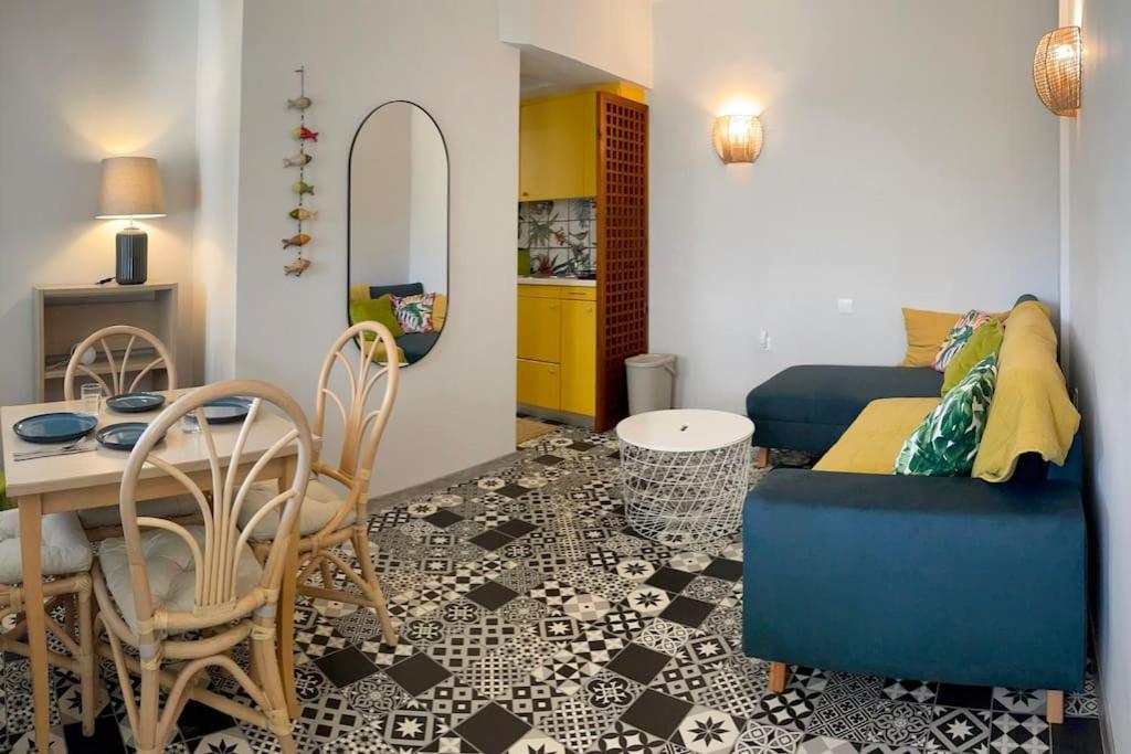 een woonkamer met een blauwe bank en een tafel bij Little Summer House in Toploú