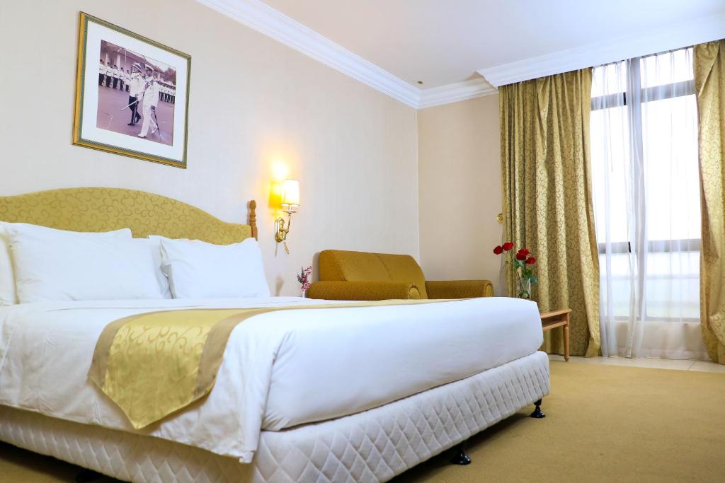 Postel nebo postele na pokoji v ubytování Merdeka Palace Hotel & Suites